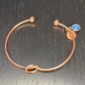 Rose gold/copper colored bracelet with knot and “N” and blue charms